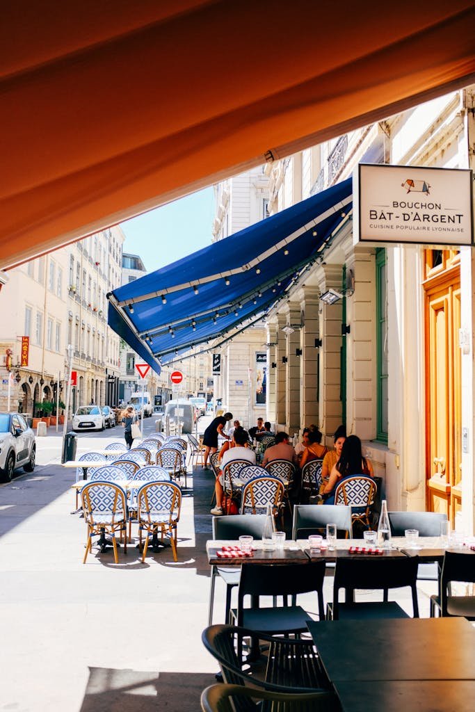 Stores de rue abritant des gens en terrasse. Livraison Cap d'Agde et ses alentours